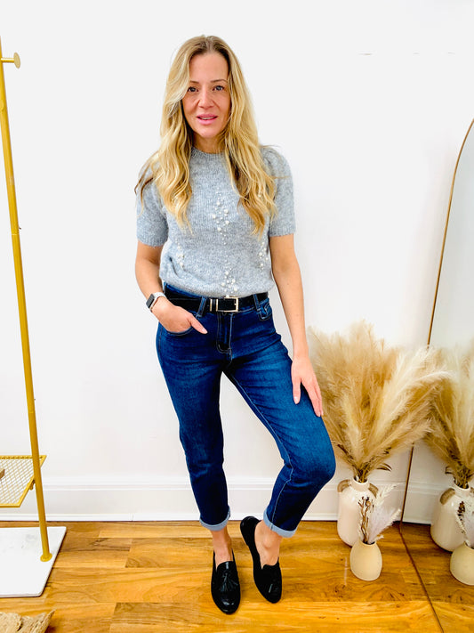 Grey short sleeve pearl jumper with dark denim mon fit jeans with black faux leather belt and faux leather loafer.