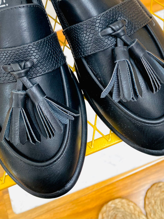 Front view of Black faux leather snake print tassel loafer with apron toe.