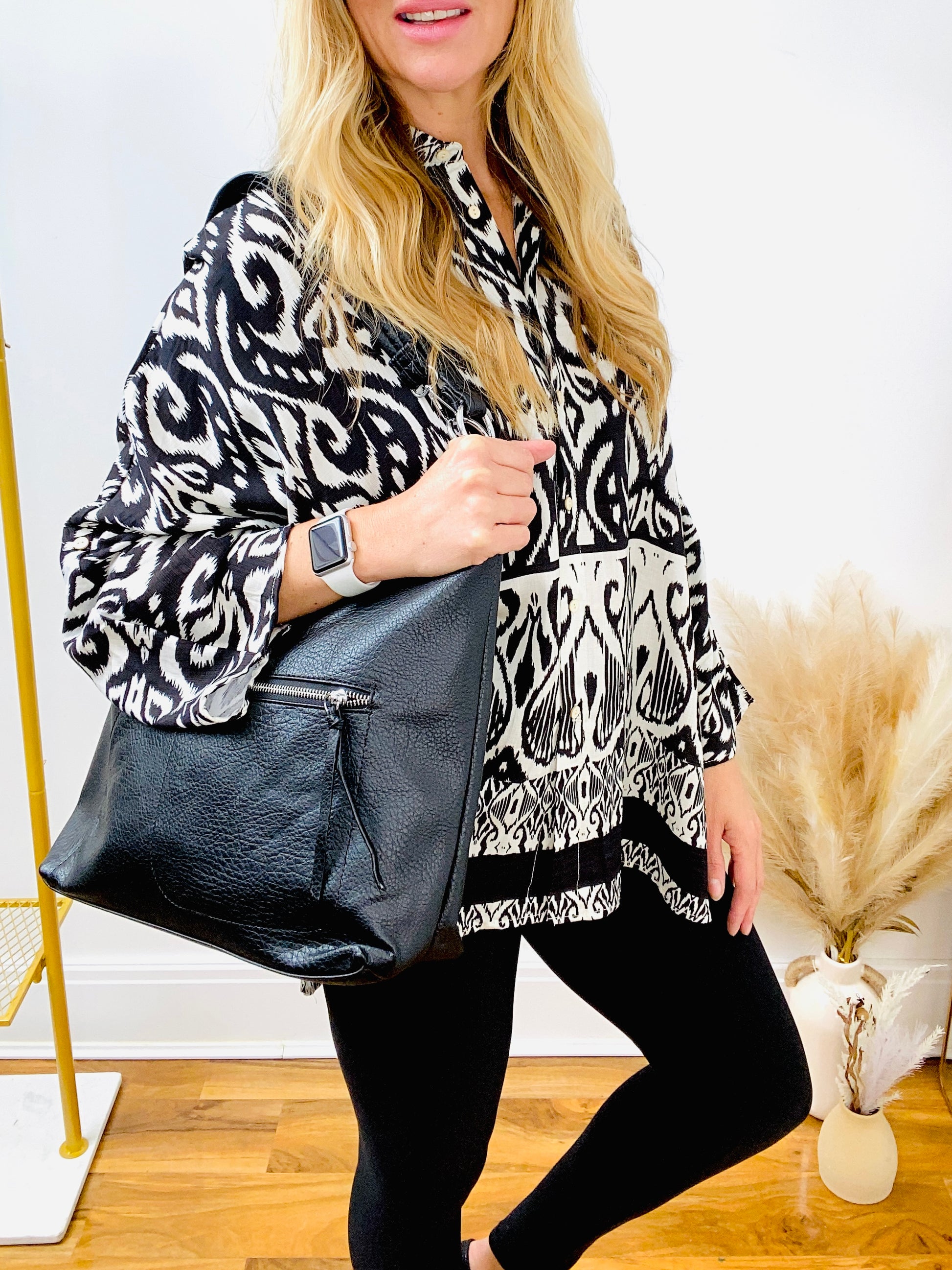 Black & white oversized paisley print shirt with black slouch faux leather bag