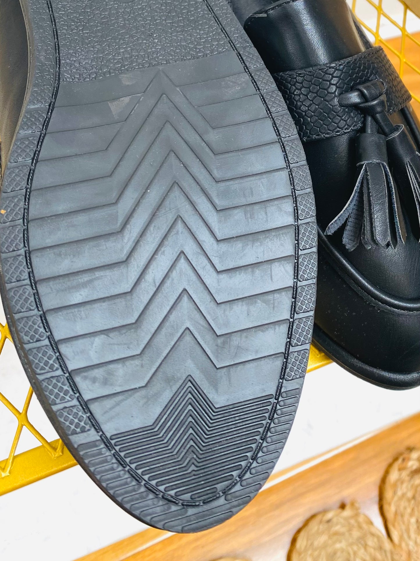 Black faux leather snake print tassel loafer, sole view.