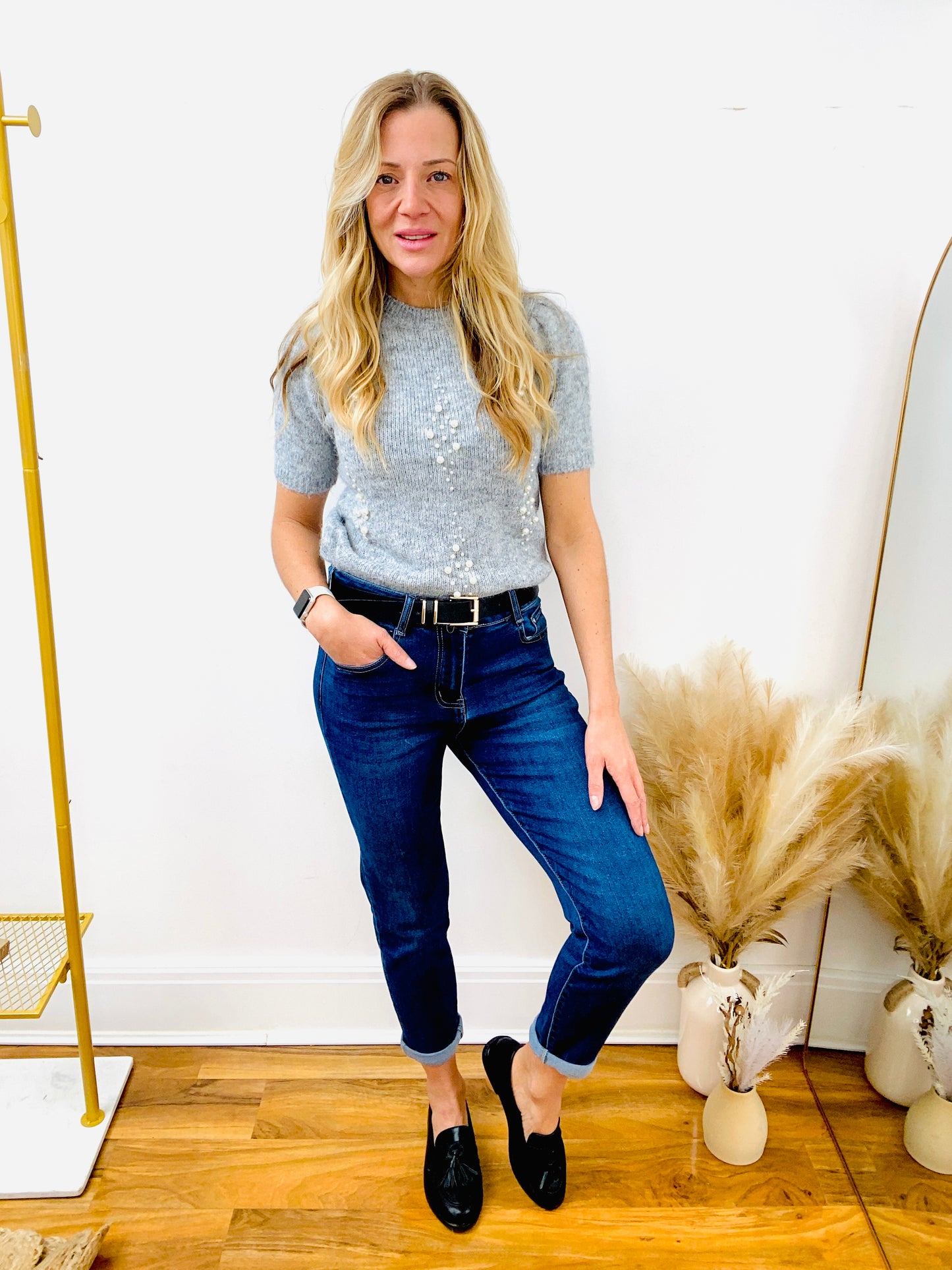 Grey short sleeve jumper with pearls and dark denim ladies jeans and black belt and black faux leather loafers.
