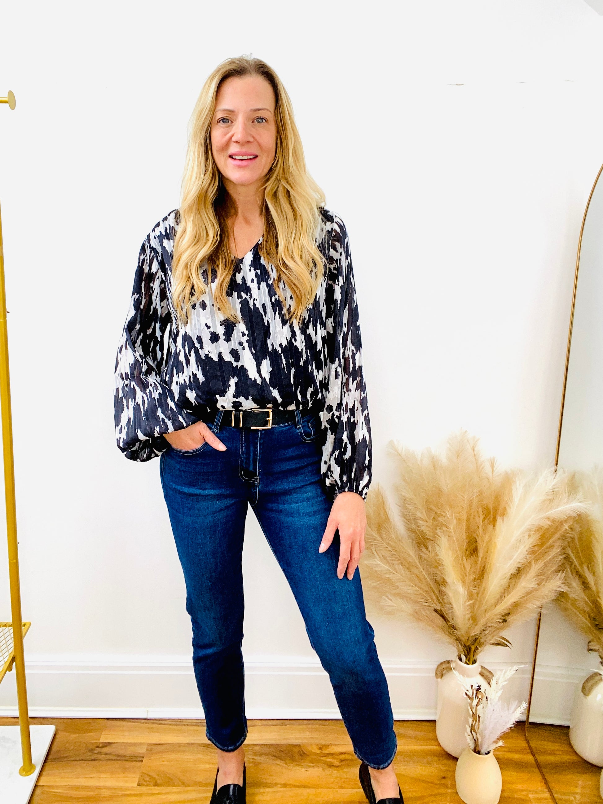 Black and white animal print blouse with dark denim mom jean with black belt