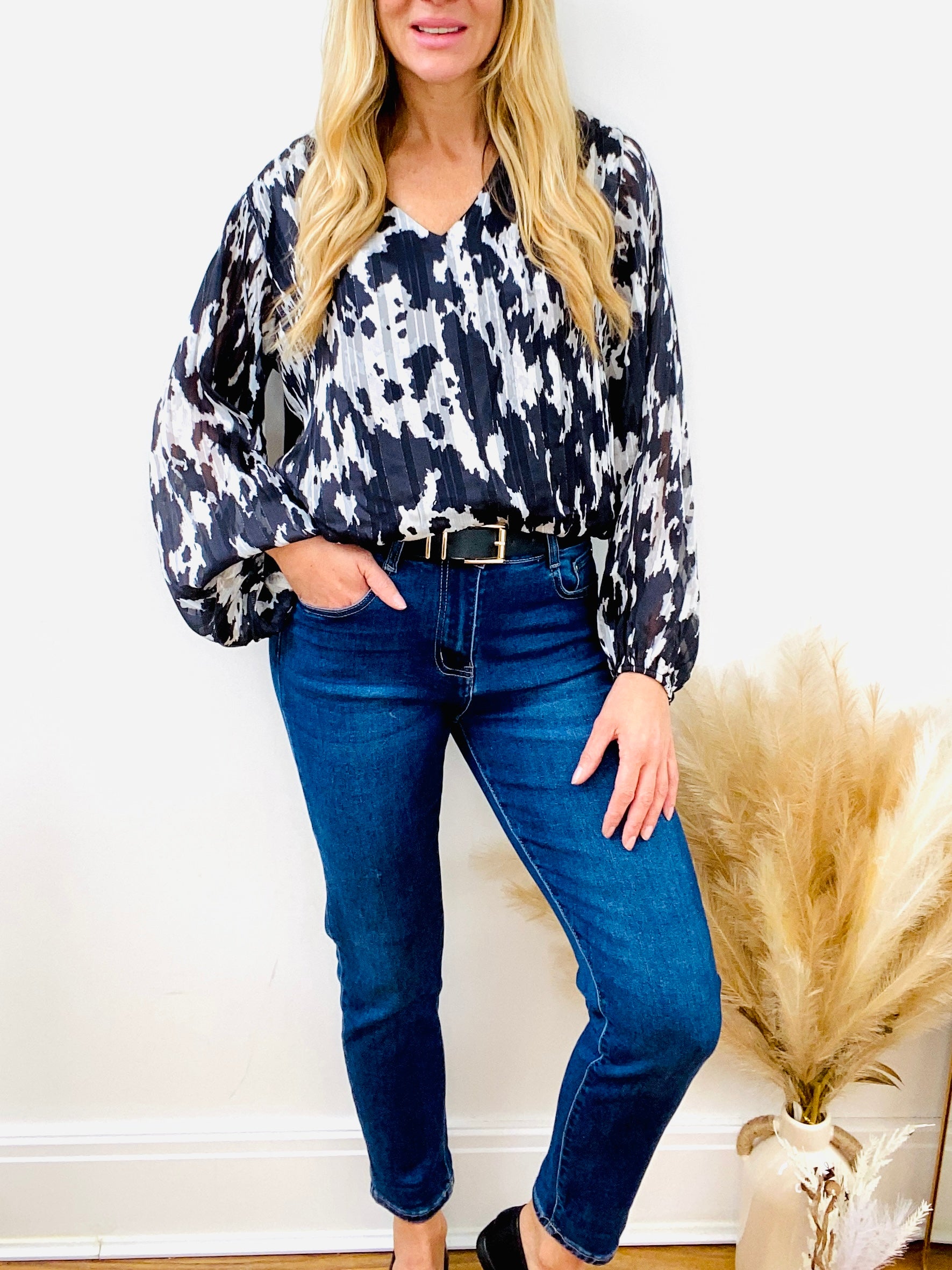Black and white animal print blouse with dark denim mom jean with black belt