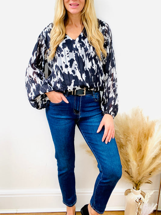 Black and white animal print blouse with dark denim mom jean with black belt